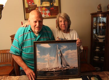 Clanton's Henry Edward Moore and wife, Joan, hold a picture of their boat "Sweet Talk" which the couple built years ago. Now, the couple spends time looking over stacks of photo albums and ship logs to remember their travels on the boat. 
